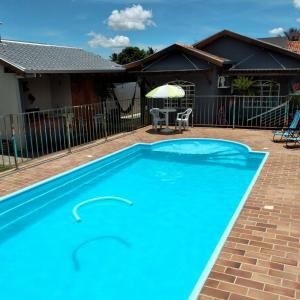 a large blue swimming pool in front of a house at Pousada e Hotel Italian Garden House in Campo Grande