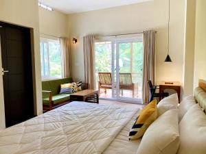 蒙纳Flower Valley Plantation Homestay的一间带大床的卧室和一间客厅