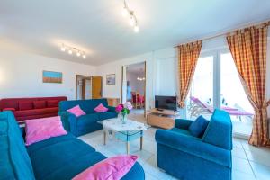 a living room with two blue couches and a table at Villa NONA in Cavtat