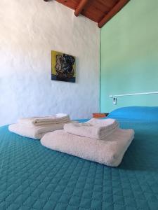 a bedroom with two beds with towels on them at Posada Costa del Sol in Colón