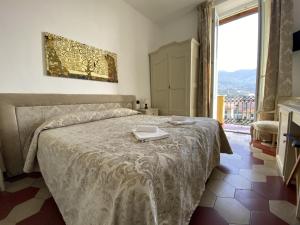 
a hotel room with a bed, table and window at Villa Margherita in Levanto
