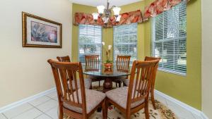 a dining room with a table and chairs and windows at Luxury Villa with Private Pool on Windsor Hills Resort, Orlando Villa 4857 in Orlando