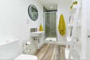 Woodland View في يورك: حمام أبيض مع حوض ومرآة