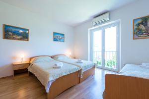 a bedroom with two beds and a window at Villa NONA in Cavtat