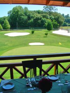 a table with a view of a golf course at Hotel Aldama Golf in Quintana de Llanes