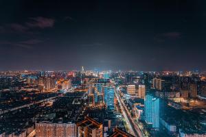 een uitzicht op de stad 's nachts met bij Kunming Bonjour Condo Hotel in Kunming