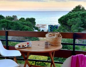 a table on a balcony with a view of the ocean at Canyelles Apartament in Roses