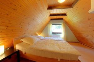 a bed in a room with a wooden ceiling at WB2 Dat luette Hus in Dorum