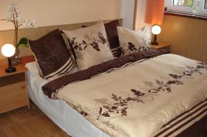 Cama con sábanas y almohadas marrones y blancas en Willa u Marii en Zakopane