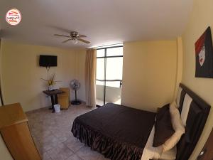 a bedroom with a bed and a ceiling fan at Hostal Huacachina Sunset in Ica