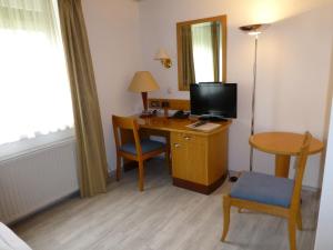 Camera con scrivania, TV e sedia. di Bed & Breakfast Bulligan a Lindau