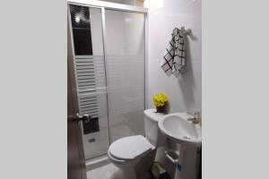 y baño con aseo, lavabo y ducha. en Piso 3-Apartment near to Cali airport en Palmira