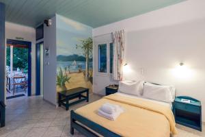 a bedroom with a large bed and a balcony at Akroyali Hotel & Villas in Agios Andreas