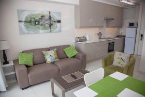 a living room with a couch and a kitchen at 413 BREAKERS RESORT UMHLANGA in Durban