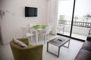 a living room with a table and chairs and a television at Breakers Resort, 413 Umhlanga Beachfront in Durban