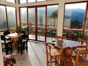 - une salle à manger avec des tables, des chaises et des fenêtres dans l'établissement Hotel Salento Mirador, à Salento