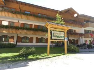 een bord voor een groot gebouw bij NRH Laurin Karersee in Nova Levante