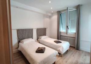 a bedroom with two beds with towels on them at Appartement spacieux centre Aix les Bains in Aix-les-Bains