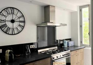 a kitchen with a clock on the wall and a stove at Appartement spacieux centre Aix les Bains in Aix-les-Bains