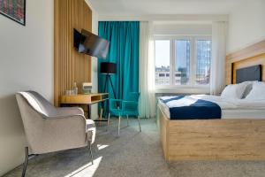 Habitación de hotel con cama, escritorio y TV. en Bed & Breakfast Sky City Center, en Zagreb