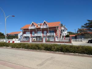 a large red house on the side of a street at Joussac Côté Plage - Devant l'océan in Soulac-sur-Mer