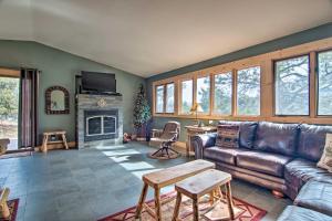 a living room with a leather couch and a fireplace at Estes Park Home with AC - half Mi to Lake and Downtown! in Estes Park