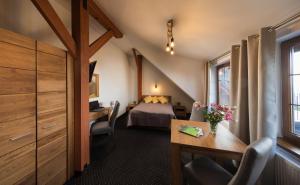 a hotel room with a bed and a desk and a table at Hotel Beskidzki Raj Medical SPA in Stryszawa +124 photos