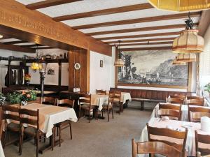 a restaurant with tables and chairs and a painting on the wall at Hotel zu den Burgen in Kamp-Bornhofen