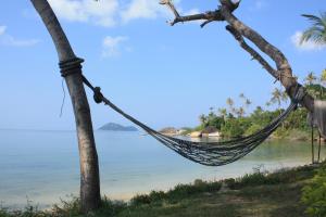 a hammock hanging from a tree on a beach at Grand Sea Beach Resort in Haad Pleayleam
