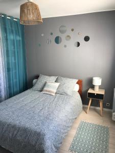 a bedroom with a bed with a blue comforter at Cabourg - Bel appartement lumineux avec balcon dans résidence privée in Cabourg