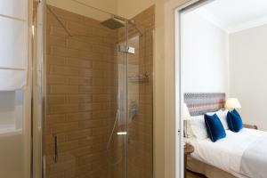 a shower in a bedroom with a bed and a glass door at GMarconi Suites in Campobasso