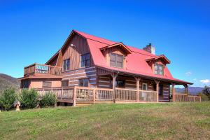 una gran casa de madera con techo rojo en Stunning Cabin: 7 Acres, 360 Views, 20min to Park!, en Sevierville