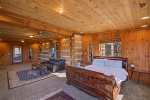 Un dormitorio con una cama y un sofá en una cabaña. en Stunning Cabin: 7 Acres, 360 Views, 20min to Park!, en Sevierville