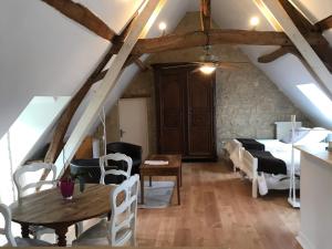 a attic room with a table and a bedroom at La Balastière in Beaumont-en-Véron