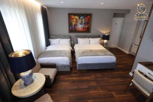 une chambre d'hôtel avec deux lits et un canapé dans l'établissement Villa Domenico Korce, à Korçë