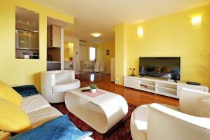 Una sala de estar con muebles blancos y un televisor de pantalla plana. en Apartment Bella Art, en Belgrado