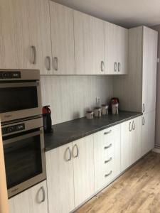 een keuken met witte kasten en een fornuis bij Sighisoara apartment in Sighişoara