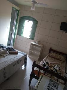 um quarto com duas camas e uma janela em Pousada Encanto e Magia em São Tomé das Letras