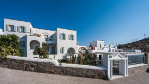 a group of white buildings with a stone wall at Parian Lithos Residence in Naousa