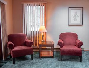 une chambre avec deux chaises, une table et une lampe dans l'établissement Fairmont Hot Springs Resort, à Fairmont Hot Springs