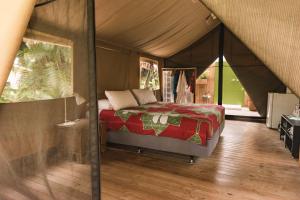 ein Schlafzimmer mit einem Bett in einem Zelt in der Unterkunft Ikurangi Eco Retreat in Rarotonga