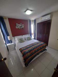 Un dormitorio con una cama grande con una manta. en Cartagena - Torremarina, en Cartagena de Indias