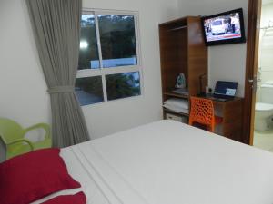 1 dormitorio con cama, escritorio y ventana en Flat Easy Green Sunset 316, en João Pessoa