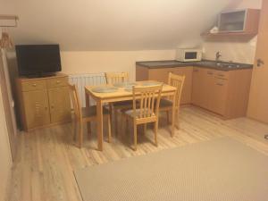 a kitchen with a table and chairs and a television at Anonim apartman in Villány