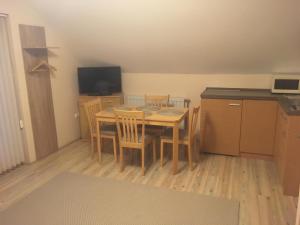 eine Küche mit einem Tisch und Stühlen im Zimmer in der Unterkunft Anonim apartman in Villány
