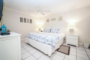 a white bedroom with a bed and two night stands at Coral Reef Club by Panhandle Getaways in Destin