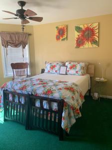 a bedroom with a bed with a comforter and a fan at Moab Beds Xpress Inn in Moab