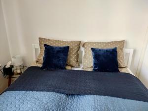 Schlafzimmer mit einem Bett mit blauer Bettwäsche und Kissen in der Unterkunft Apartman HANA in Travnik