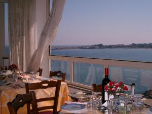 a dining table with a view of the water at Hotel La Riva in Giardini Naxos