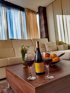 舒門的住宿－阿克申酒店，桌子上放有一瓶葡萄酒和两杯酒